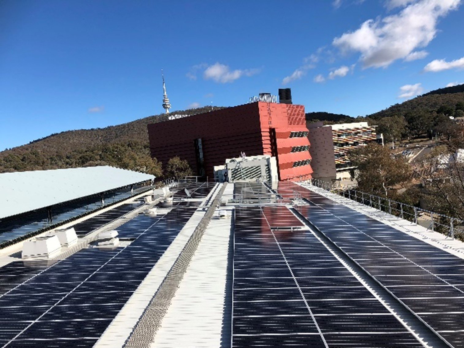 Rooftop solar array at CSIRO Black Mountain, with the tower on the ridge behind